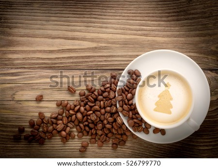 coffee cup with drawing christmas tree and coffee beans on wooden background flat lay