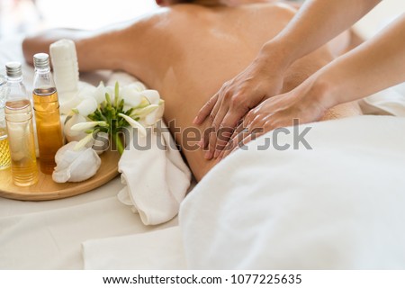Young beautiful Asian woman sleep relaxing in the Oil spa massage in salon. Select focus hand of masseuse