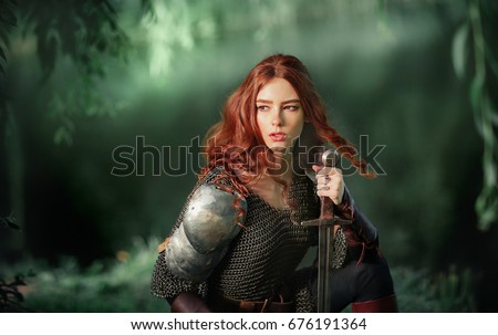 Beautiful red haired girl in metal medieval armor dress with swords sitting in warlike pose near river and looking afar. Fairy tale story about warrior . Glowing light. Warm art work.