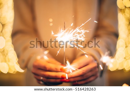 Close up of woman hands holding sparkler