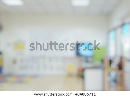 Blur abstract background of nobody kindergarten classroom. Blurred image of empty elementary classroom. Blurry view of activities classroom without kid or teacher. Defocused classroom with television.