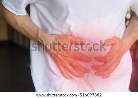Man\'s hands on his stomach with red spot as suffering on stomachache. Male suffer from Chronic Diarrhea,Digestive Disorders, stomach pain,Crohn’s Disease, Gastroesophageal Reflux Disease (GERD).