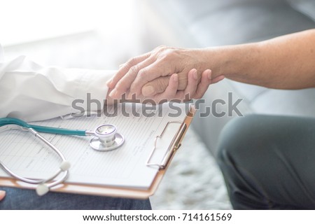 Parkinson and alzheimer female senior elderly patient with caregiver in hospice care. Old woman holding hand with doctor physician.