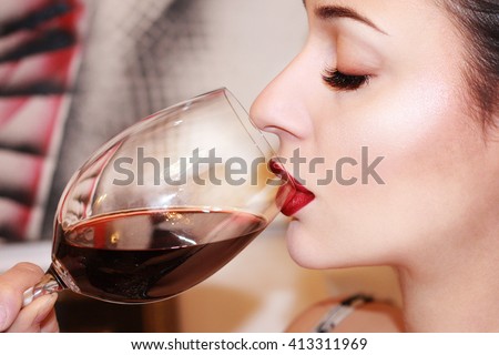 Beautiful young woman drinking red wine
