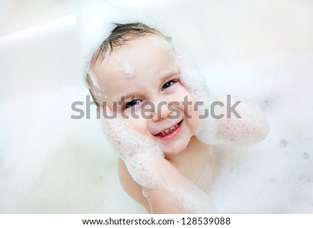 Adorable bath baby boy with soap suds on hair