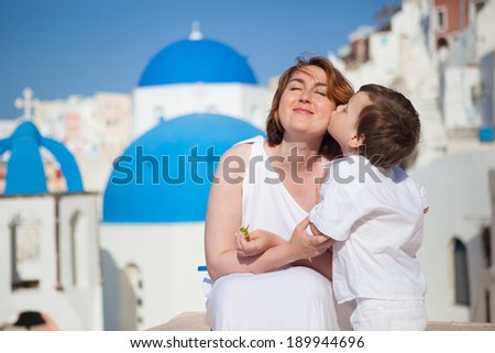 Little son kissing his mother (bride) on Santorini Island, Greece