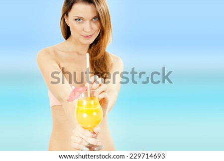 Beautiful Caucasian woman drinks cocktail on tropical island. Wearing big hat