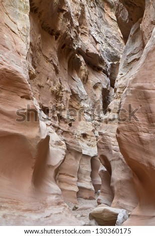 A hiking path winds through colorful folds in Little Wild Horse Slot Canyon near Goblin Valley State Park in Utah