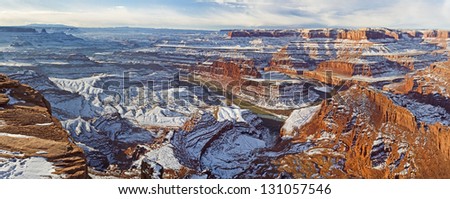 Panoramic wintry view of a gooseneck bend in the Colorado River and Canyonlands National Park from Dead Horse Point Overlook in Utah.