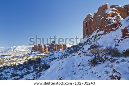 Snow-covered red rock fins with the La Sal Mountains behind  in Arches National Park in Utah