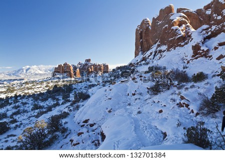 Snow-covered red rock fins above the Windows Primitive Loop Trail in Arches National Park in Utah