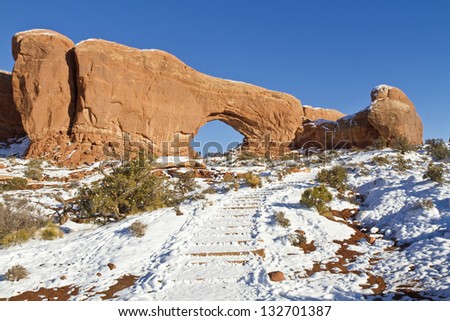 Snow-covered red rock fins above the Windows Primitive Loop Trail in Arches National Park in Utah