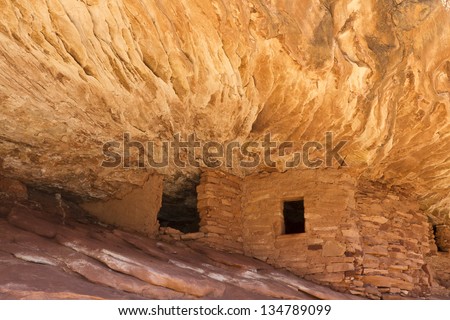 The \'House on Fire\' Puebloan ruins under  a cliff in Mule Canyon in the Cedar Mesa Plateau of Utah look like the ancient stone granaries and dwellings are on fire.