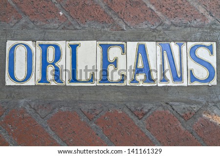 SIdewalk street sign for Rue Orleans in the French Quarter of New Orleans, Louisiana