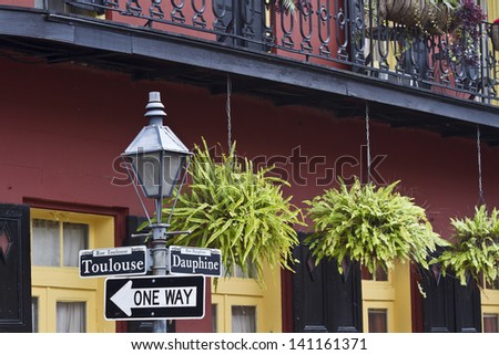 Ferns hang from a balcony railing on the corner of Toulouse and Dauphine in the French Quarter of New Orleans, Louisiana