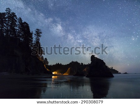 The Milky Way lights up the southern sky while a campfire illuminated the seas stacks on Ruby Beach in Olympic National Park, Washington.