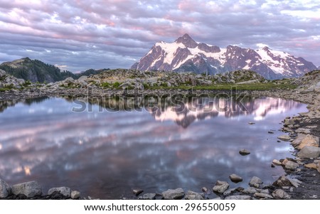 Mt Shuksan and colorful sunset clouds reflected in a tarn on Artist Ridge in Mt. Baker-Snoqualmie National Forest, Washington.
