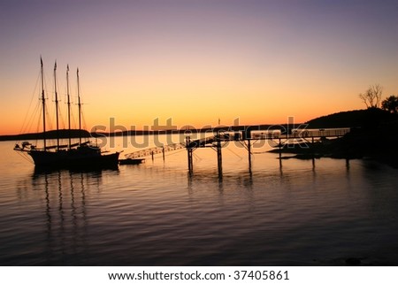 Sunrise silhouette of a windjammer tall ship tied up at dock in Bar Harbor, ME