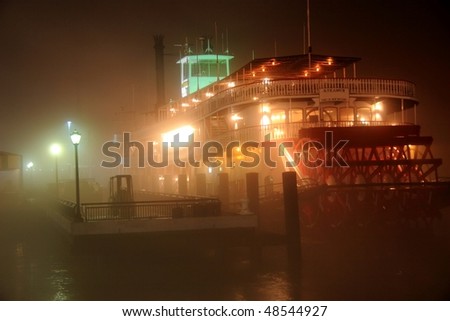 A paddle boat moored on very foggy banks of the Mississippi River in New Orleans, LA