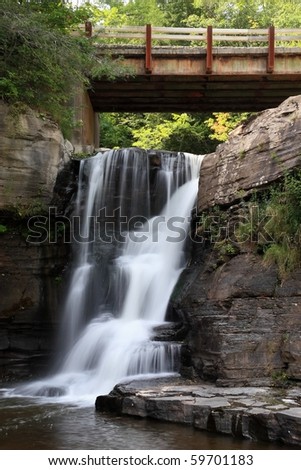 A rusty bridge over Hardenburgh Falls as it falls into the Schoharie Reservoir in the Catskills Mountains of New York