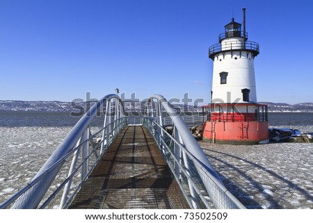 An extruded metal walkway leads to the Sleepy Hollow lighthouse on the icy Hudson River