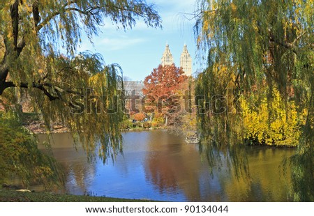 The El Dorado building seen between two willow trees on the lake in Central Park in New York City