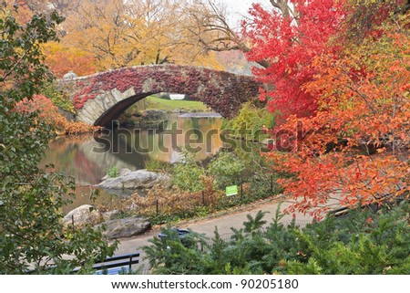 Gapstow Bridge on the Central Park Pond covered in red ivy and surrounded by beautiful fall foliage in New york City