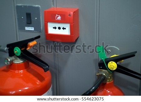 fire alarm box on wooden grey wall and two fire extinguisher and security system button