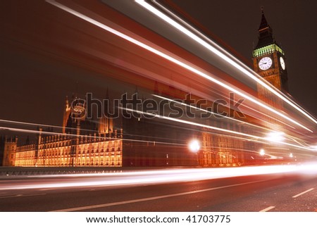 Big Ben at night with bus in motion blur.
