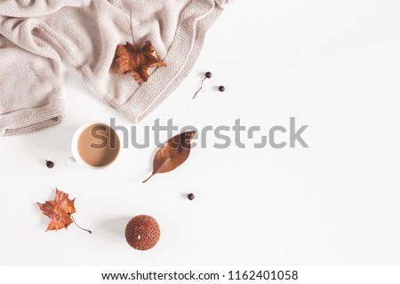 Autumn composition. Cup of coffee, women fashion csweater, autumn leaves on white background. Flat lay, top view, copy space