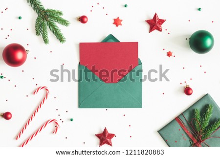 Christmas composition. Envelope, fir tree branches, red and green decorations on white background. Christmas, winter, new year concept. Flat lay, top view, copy space