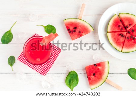 Watermelon juice, watermelon slices and spinach leaves. Top view, flat lay
