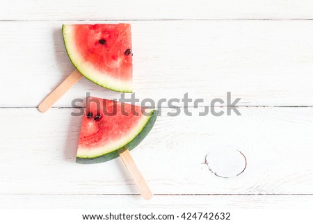 Watermelon popsicle on wooden white background. Watermelon slices on sticks. Top view, fat lay