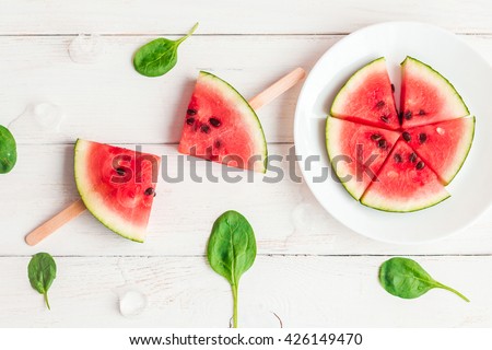 Watermelon popsicle on wooden white background. Watermelon slices on sticks. Dessert. Flat lay, top view