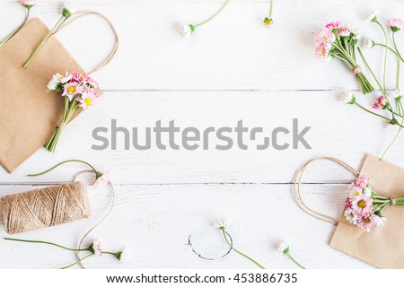 Workspace with small bouquets of daisy flowers, paper packages. Creative flowers. Top view, flat lay