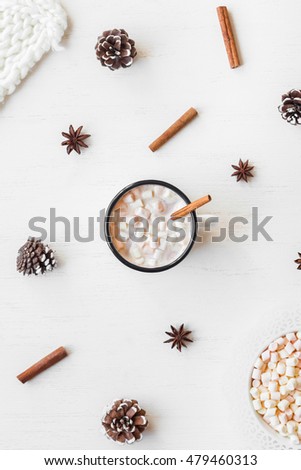 Winter drink. Hot chocolate, cinnamon sticks, anise star, marshmallow, knitted blanket and cones. Winter composition. Flat lay, top view