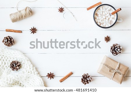Christmas composition. Hot chocolate, cinnamon sticks, anise star, marshmallow, knitted blanket, christmas gift and cones. Winter. Flat lay, top view