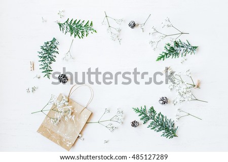 Christmas composition. Christmas gift, pine cones, thuja branches and gypsophila flowers. Top view, flat lay