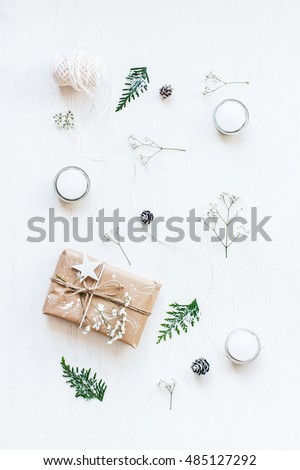 Christmas composition. Christmas gift, pine cones, thuja branches, gypsophila flowers. Top view, flat lay