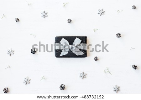 Christmas composition. Christmas gift, snowflakes, pine cones and gypsophila flowers. Top view, flat lay