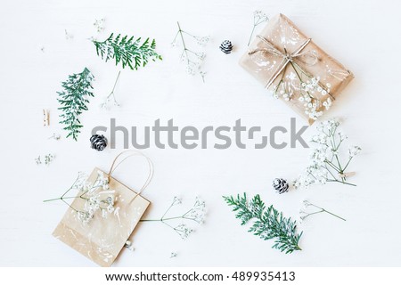 Christmas composition. Christmas gift, pine cones, thuja branches and gypsophila flowers. Flat lay, top view