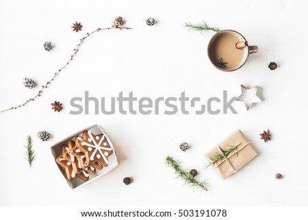 Christmas composition. Cup of coffee, gift, larch branches, cinnamon sticks, anise star, christmas cookies. Flat lay, top view