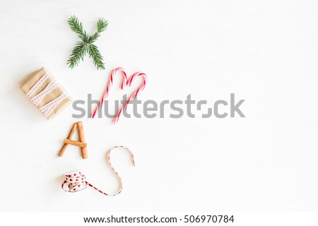 Christmas composition. Christmas candy canes, gift, cinnamon sticks and fir branches. Flat lay, top view
