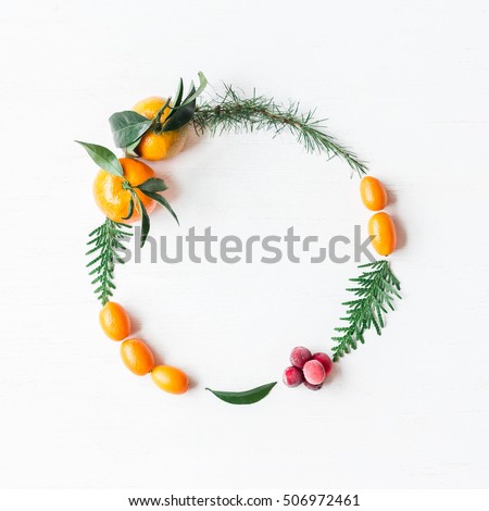 Christmas wreath with tangerines, cranberries, thuja branches, kumquats. Flat lay, top view
