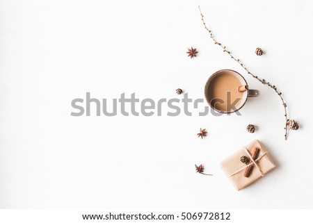 Christmas composition. Cup of coffee, larch branches, cinnamon sticks, anise star., christmas gift. Flat lay, top view