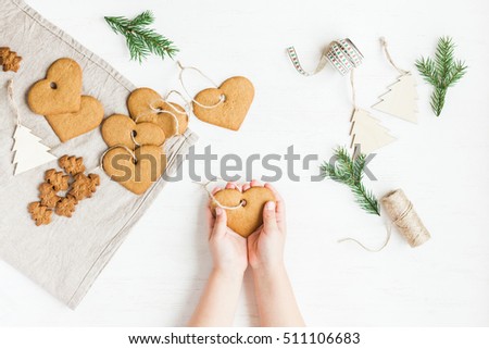 Child making christmas decoration from christmas cookies. Flat lay, top view