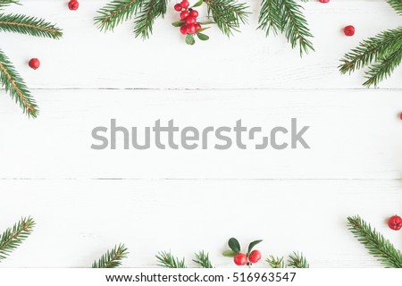 Christmas frame made of fir branches, red berries. Christmas wallpaper. Flat lay, top view
