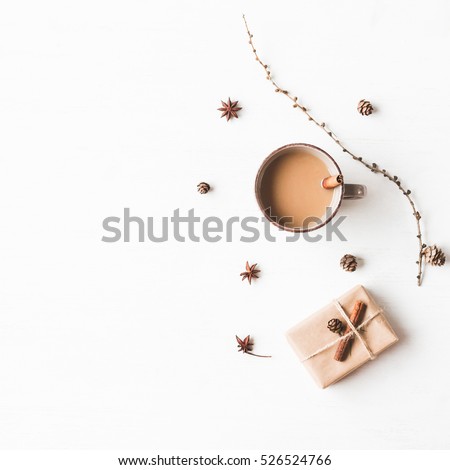 Christmas composition. Cup of coffee, larch branches, cinnamon sticks, anise star., christmas gift. Flat lay, top view.
