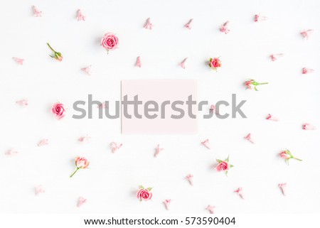 Paper blank and pink flowers on white background. Mock up with flowers. Flat lay, top view