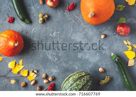 Autumn frame made of pumpkins, birch tree leaves, hazelnuts on black background. Autumn, fall, thanksgiving concept. Flat lay, top view, copy space